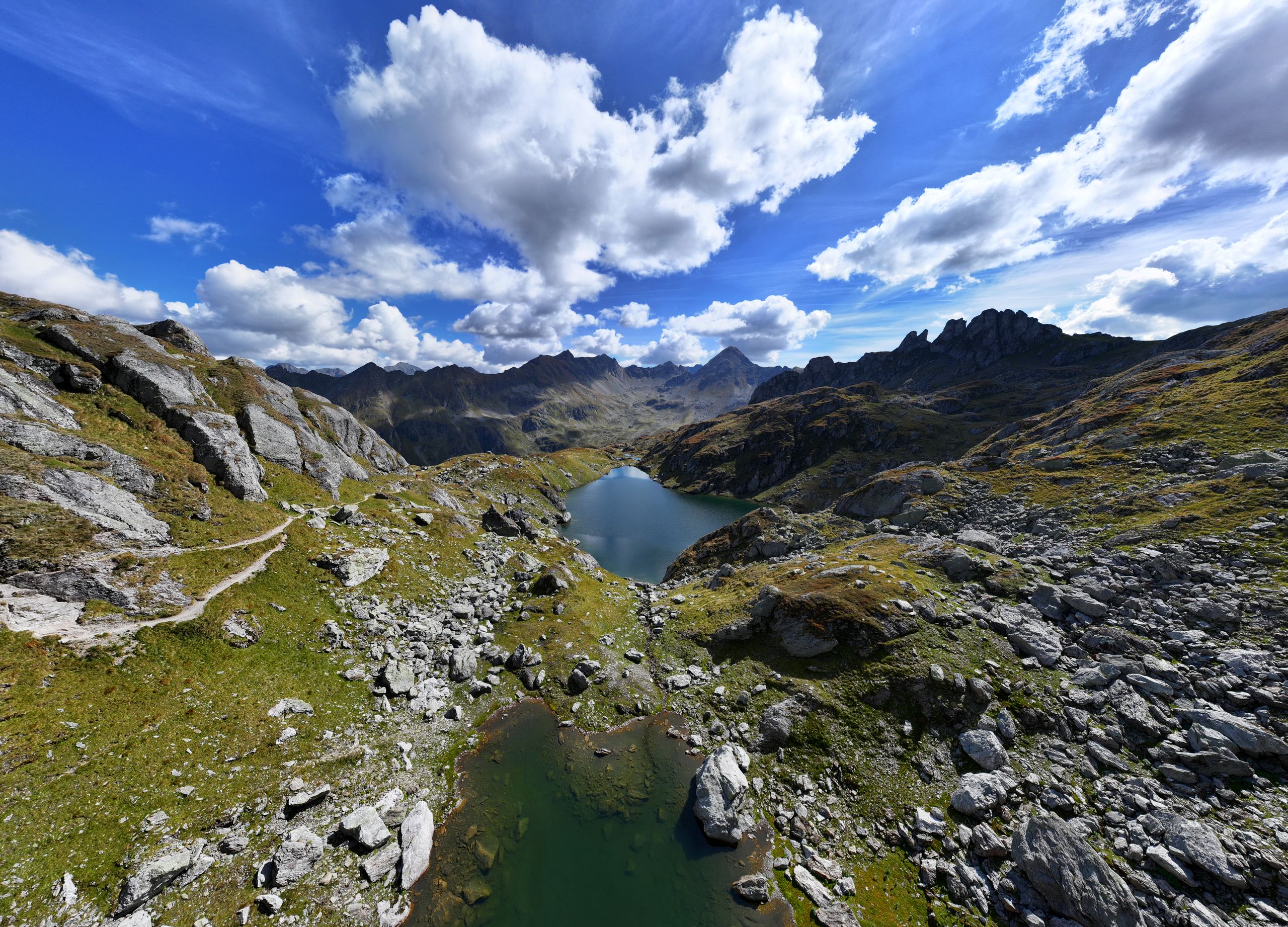 An alpine lake surrounded by rocky mountains under a blue sky